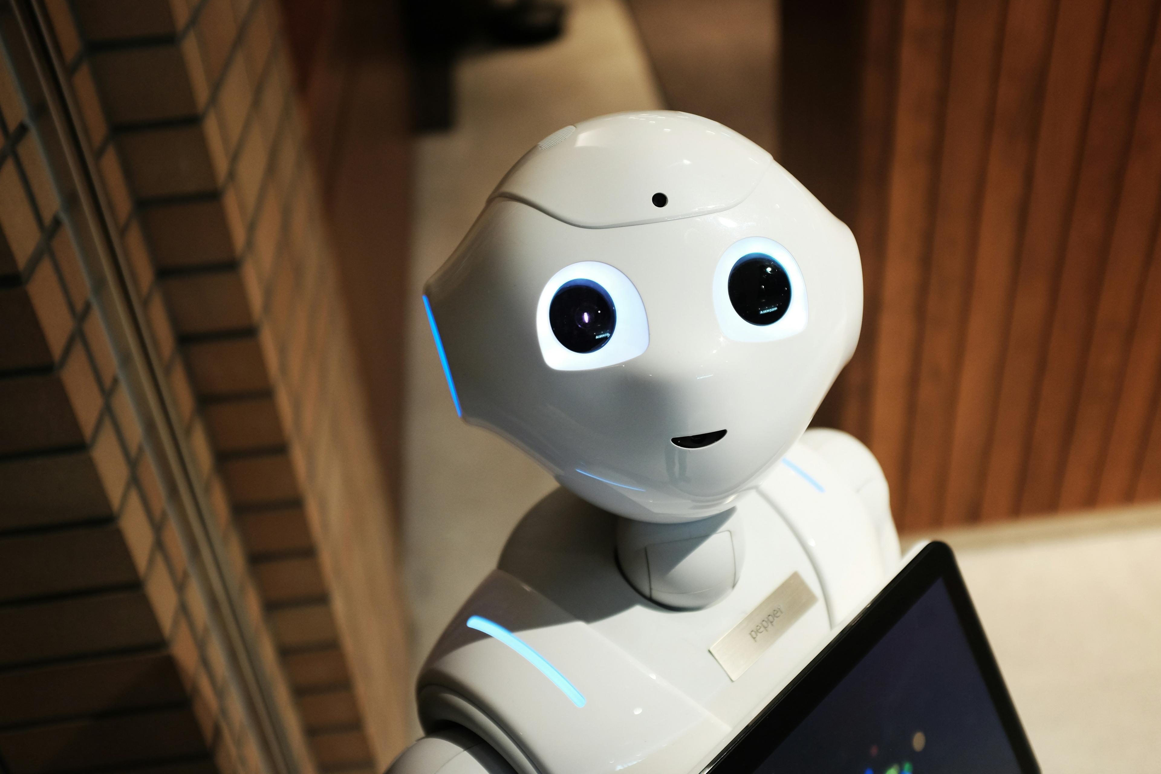 En vit humanoid robot mot en brun vägg, symbol för en AI SDR och autonoma säljagenter inom modern försäljning