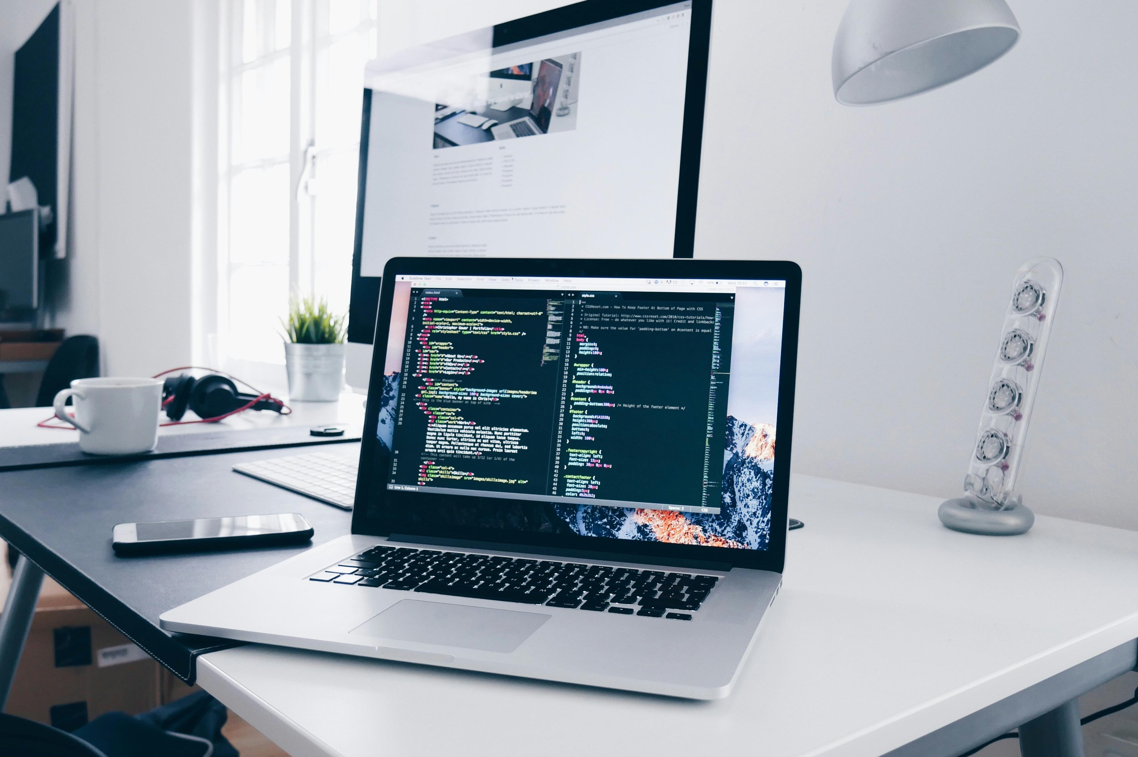 Bärbar dator med kod på skärmen som representerar no-code automation och digital arbetsflödesbygge