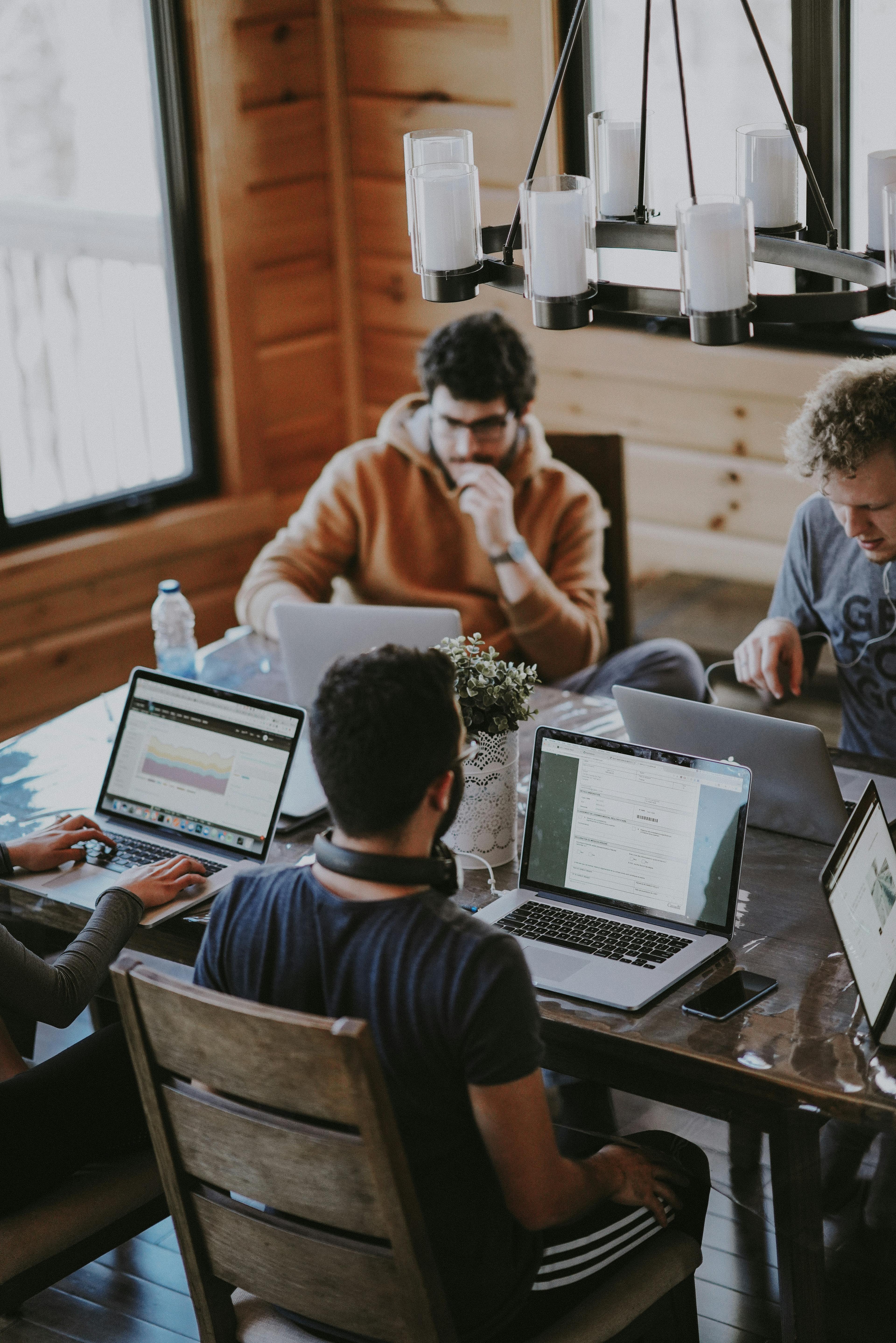 Team som samarbetar vid ett bord med laptops och diskuterar partnerhantering och affärsstrategi