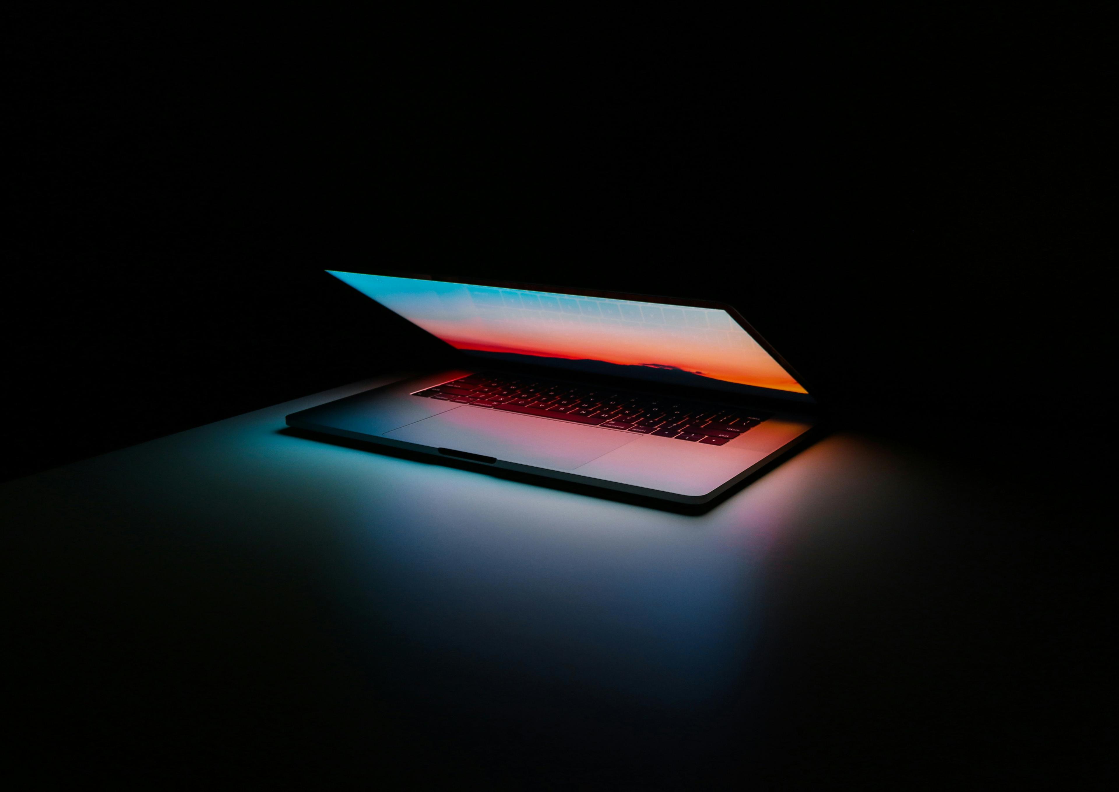 Laptop on a desk with glowing blue light representing workflow automation technology