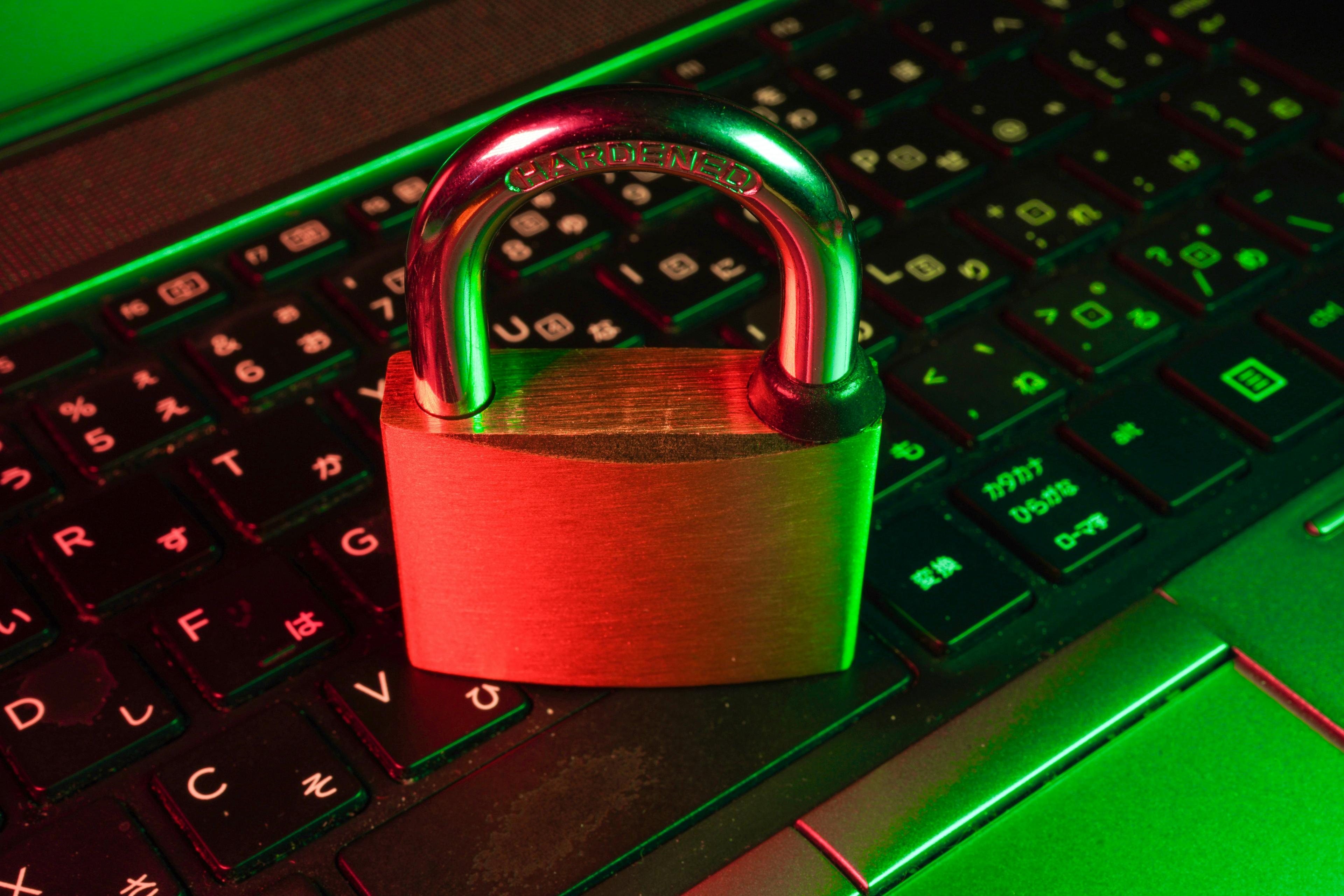 Rött hänglås på svart datortangentbord som symboliserar cybersäkerhet för företag
